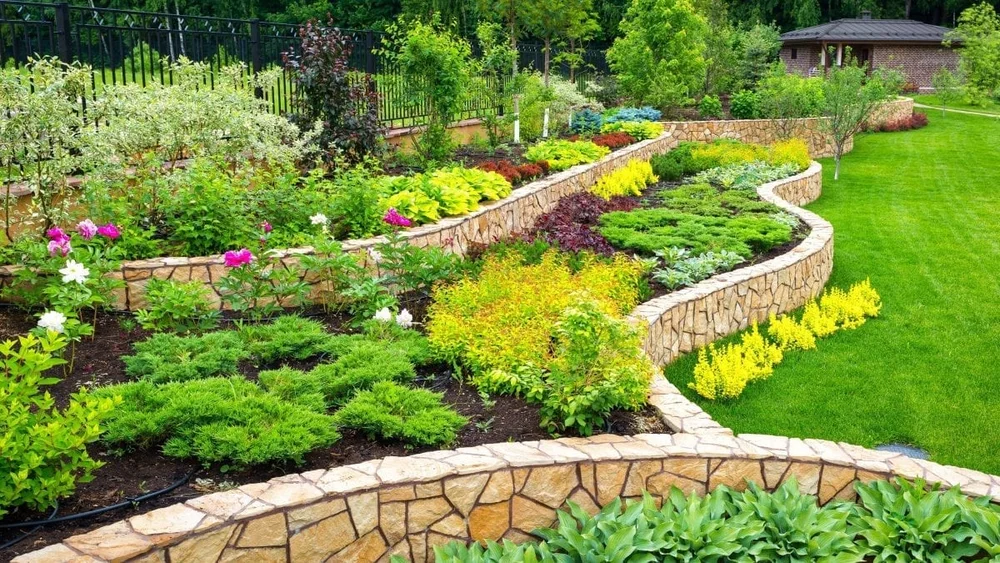 Tiered stone garden walls with mature flower beds